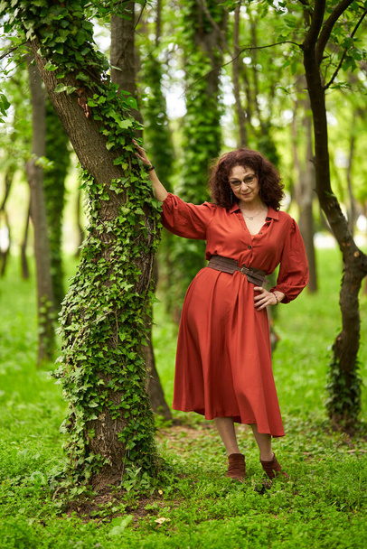 Candid portrait of a beautiful mature curly hair woman in the park - Foto, Imagem