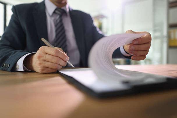 Businessman puts signature on contract sitting at table in office. Company CEO verifies commercial agreement after negotiation at desk - Foto, Imagem