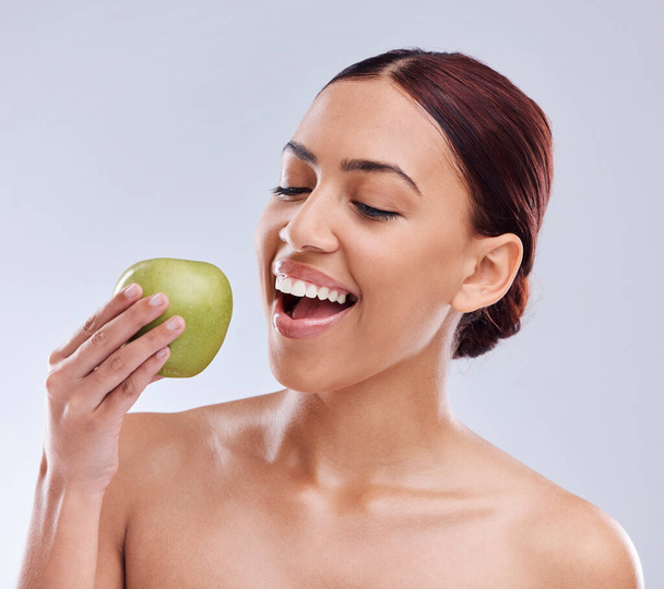 Apple, glücklich oder Frau im Studio essen auf weißem Hintergrund für gesunde Ernährung oder saubere Ernährung. Beißen, lächeln oder hungrig schöne Mädchen Werbung oder Vermarktung natürlicher Bio-Früchte für Wohlbefinden. - Foto, Bild