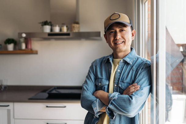Portrait with copy space of a friendly asian man standing looking at camera at home - Photo, image