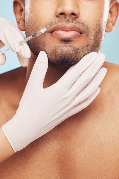 Skincare, botox and lips with a man in studio on a gray background for a plastic surgery injection. Hands, beauty and syringe with a young male patient indoor for an antiaging facial filler closeup. - Foto, Bild