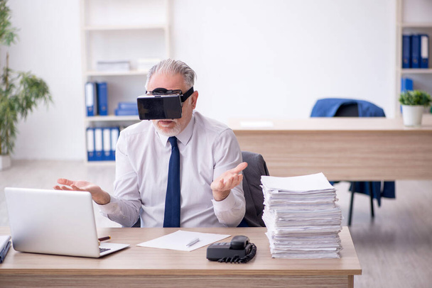 Old businessman employee wearing virtual glasses in the office - Zdjęcie, obraz