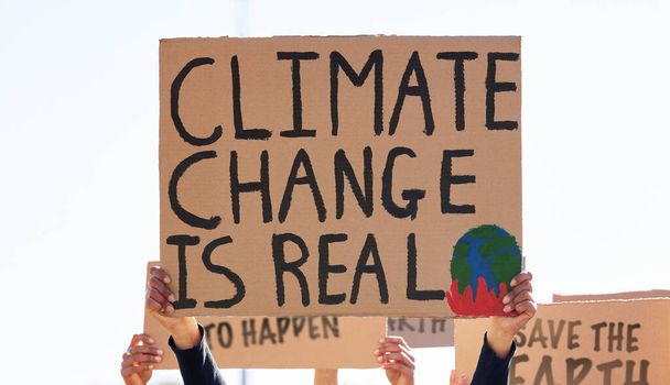 Protest, climate change and sign with a group of people outdoor at a rally or march for conservation. Global warming, freedom and environmental with a crowd walking together during a community strike. - Photo, Image