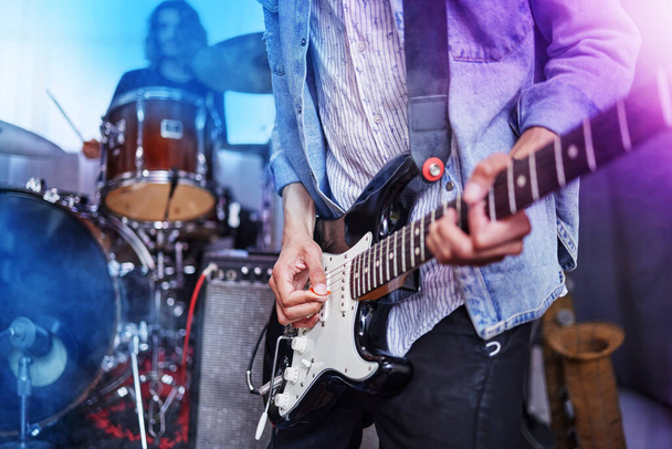 Guitar, band and man hands at music festival show playing rock with electric instrument with lights. Sound, musician and party with live talent and audio for punk event with people at a concert. - Photo, Image