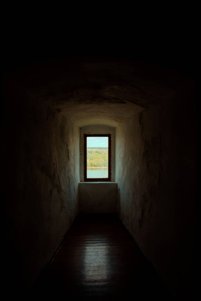 Fenster in der alten Festung mit Blick auf den Fluss, dunkler architektonischer Hintergrund. Hochwertiges Foto - Foto, Bild