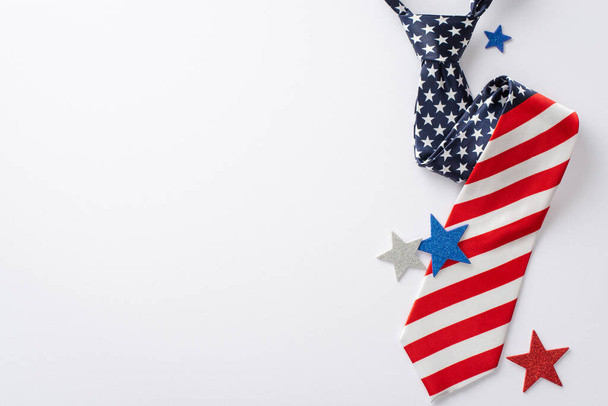 Patriotic party setup for Independence Day: top view shimmering stars, and silk necktie with American flag pattern, displayed on a white background with blank area for text or promotional content - Zdjęcie, obraz