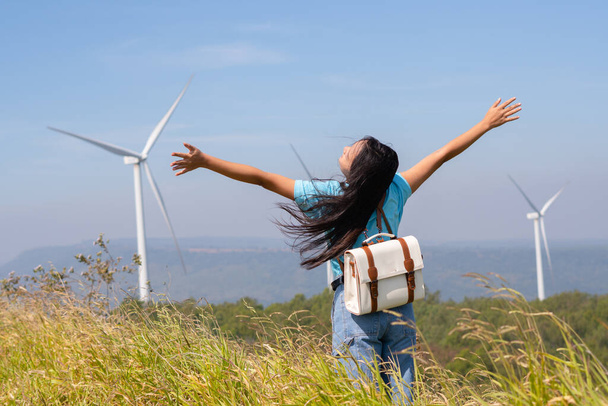 Traveler girl turn back looking beautiful view of mountain and Wind Turbine, Khao Yai Thieng Electric Wind Turbine Thailand. - Zdjęcie, obraz