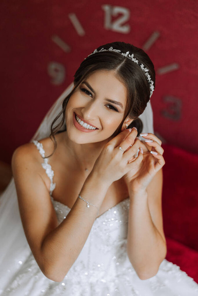 Beautiful bride with a fashionable wedding hairstyle, wedding nude makeup. Close up portrait of young gorgeous bride, posing in room in the wedding morning. High quality photo - Foto, imagen