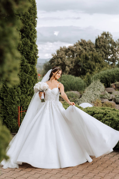 Beautiful bride with wedding flowers bouquet, attractive woman in wedding dress. Happy newlywed woman. Bride with wedding makeup and hairstyle. Smiling bride. Wedding day. Gorgeous bride. Marriage. - Foto, afbeelding