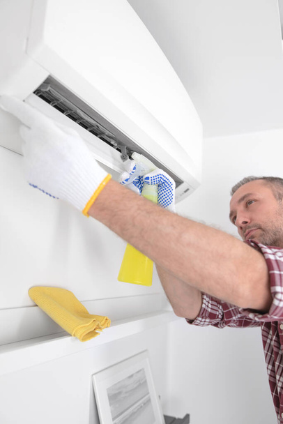 Service guy cleaning and maintaining air condition unit. - Photo, Image