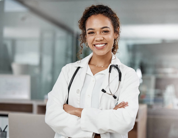 Healthcare, portrait of woman doctor with arms crossed and with stethoscope in a hospital building happy with a lens flare. Medical, wellness and female surgeon or nurse smile excited in a clinic. - Photo, Image