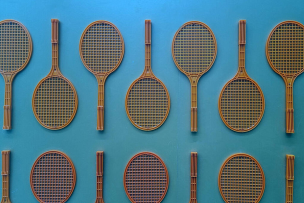 Niebieskie tło ze starymi rakietami do tenisa i badmintona - Zdjęcie, obraz