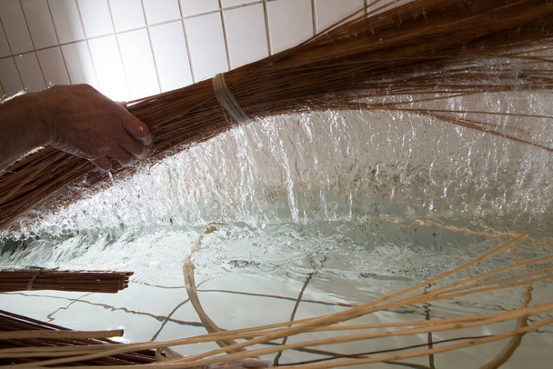 un fabricant de paniers tisse un panier, l'artisanat et la production avec du bois - Photo, image
