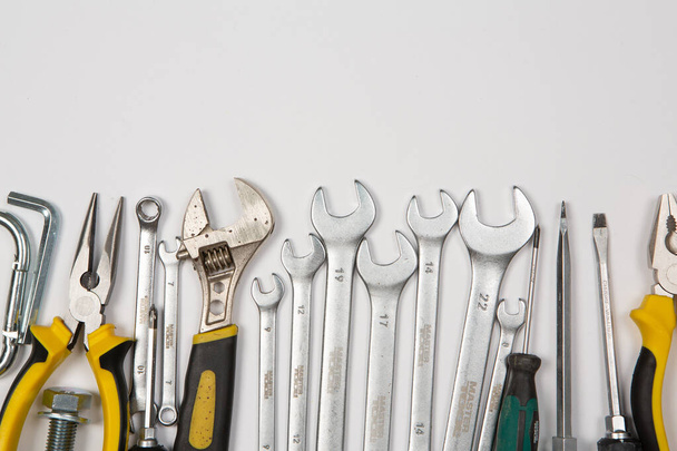 Ensemble d'outils pour la réparation dans un boîtier sur un fond blanc. Travaux ou outils de construction variés. Clés, pinces, tournevis. Vue du dessus - Photo, image