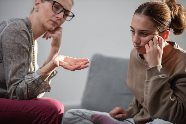 Madre hablando con difícil hija adolescente en casa. - Foto, imagen