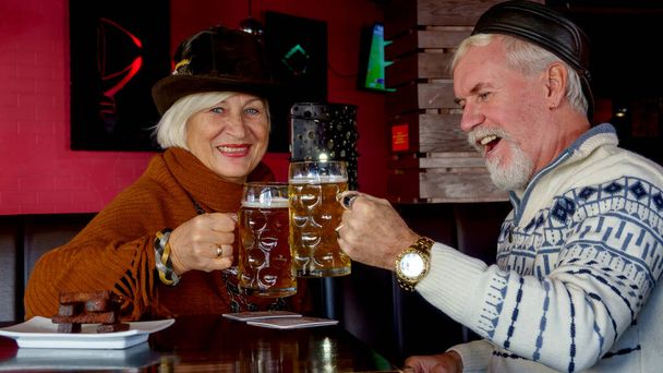 Carino coppia anziano uomo e donna in un bar di birra rilassante con un bicchiere di birra - Foto, immagini
