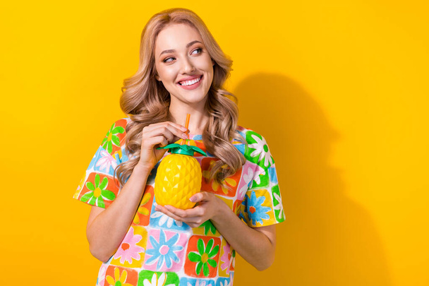 Photo of cheerful nice girl wavy hairdo dressed colorful t-shirt hold pineapple cup look empty space isolated on yellow color background. - Valokuva, kuva