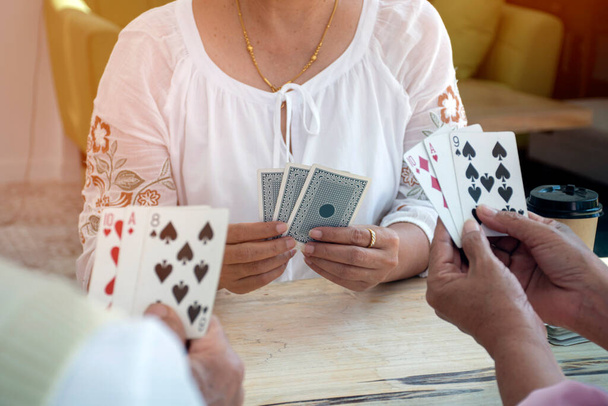 Nyugdíjasok kártyáznak az idősek otthonában, az idősek boldogsága nyugdíjba vonulásuk után kártyázással otthon. - Fotó, kép