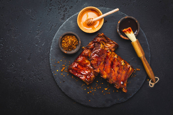 Barbecue pork spare ribs with hot honey chili marinade on black background - Foto, Imagen