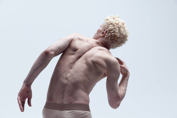 Портрет м'язистого без сорочки, який позує в нижній білизні і стоїть як статуя, ізольована на білому студійному фоні. Концепція естетики чоловічого тіла, чоловіча краса, натхнення, мистецтво
 - Фото, зображення