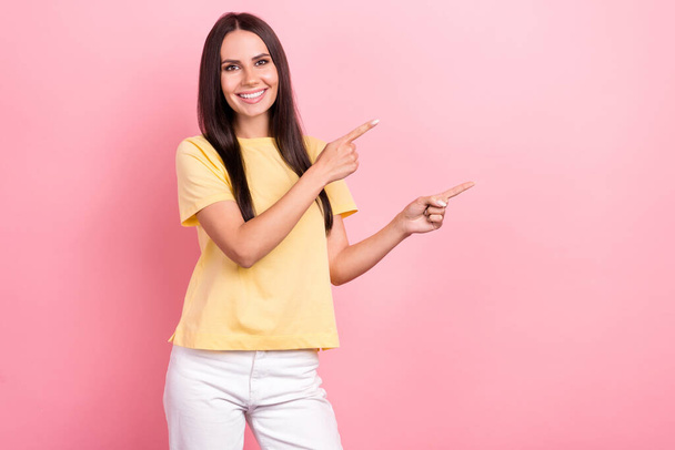 Photo of attractive lady promoter showing empty space banner proposition wear yellow shirt isolated pink color background. - Фото, зображення