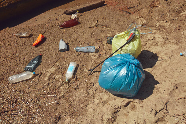 Verzameld afval weggegooid op de oever van de rivier. - Foto, afbeelding