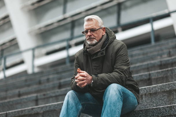 Prayer to God. An elderly man sits outdoors hoping. Thinks alone, depressed. - Fotografie, Obrázek