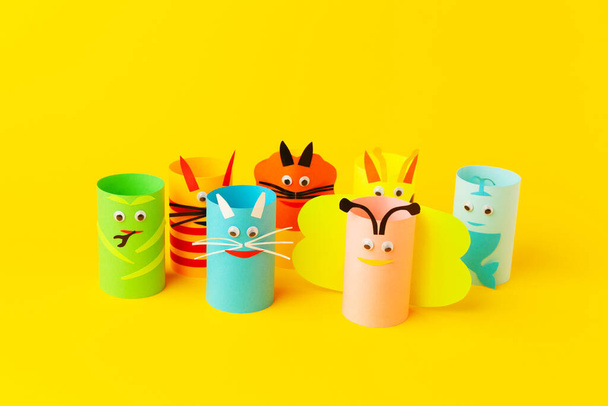Handmade paper toys from toilet rolls, on yellow background. - Фото, изображение