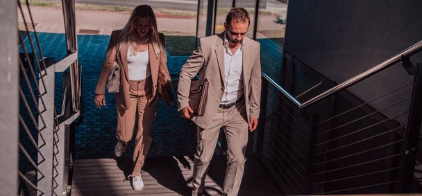 Modern business couple after a long days work, walking together towards the comfort of their home, embodying the perfect blend of professional success and personal contentment - Foto, imagen