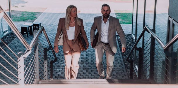 Modern business couple after a long days work, walking together towards the comfort of their home, embodying the perfect blend of professional success and personal contentment - Foto, Imagem