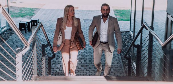 Modern business couple after a long days work, walking together towards the comfort of their home, embodying the perfect blend of professional success and personal contentment - Fotoğraf, Görsel
