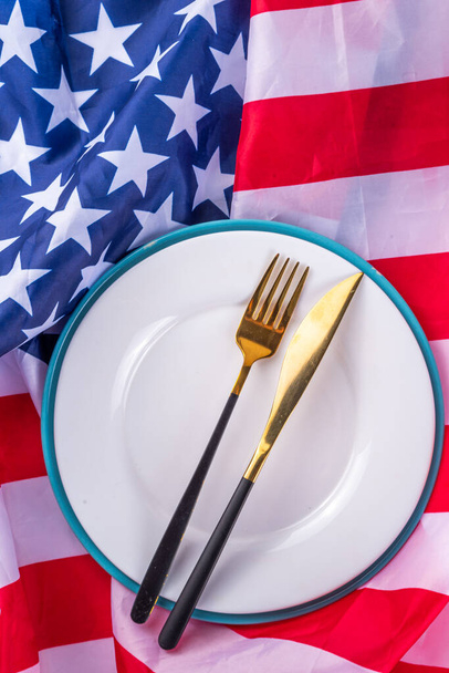 USA patriotic table setting with american flag, plate and decoration in national flag colors on white background. Independence Day. Happy Memorial Day dinner menu background top view copy space - Foto, Bild