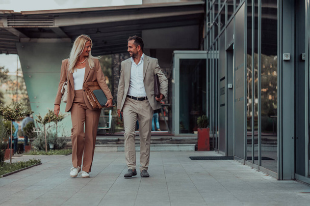 Modern business couple after a long days work, walking together towards the comfort of their home, embodying the perfect blend of professional success and personal contentment - Fotografie, Obrázek