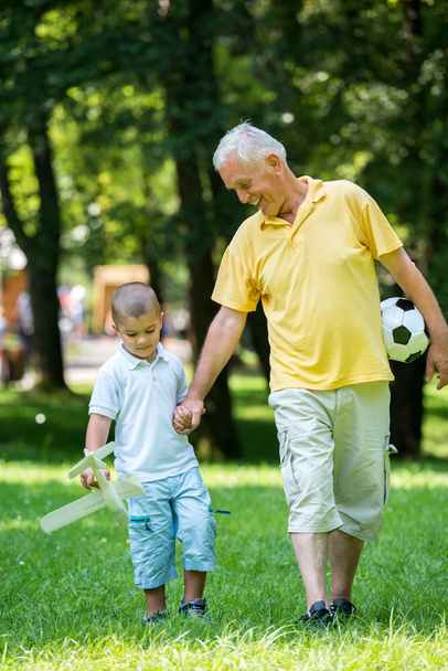 Grandfather and child have fun in park - Foto, imagen