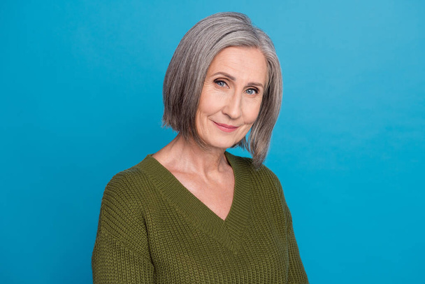 Portrait of nice good mood pensioner grandmother with gray hairdo wear knit pullover look at camera isolated on blue color background. - Фото, изображение