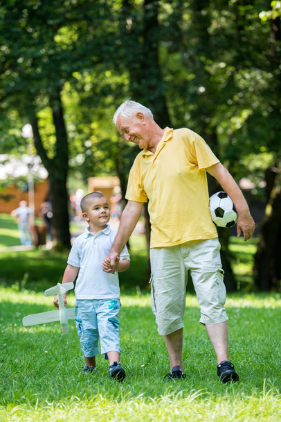 Grandfather and child have fun in park - Foto, Imagen
