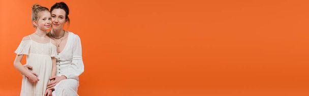 amor materno, jovem mulher feliz abraçando menina pré-adolescente no fundo laranja, vestidos de sol branco, moda de verão, união, amor, ligação feminina, mãe e filha, banner  - Foto, Imagem