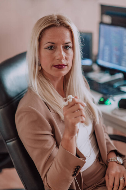 A businesswoman sitting in a programmers office surrounded by computers, showing her expertise and dedication to technology - Foto, Bild