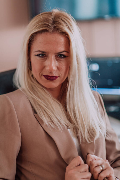 A businesswoman sitting in a programmers office surrounded by computers, showing her expertise and dedication to technology - Foto, Bild