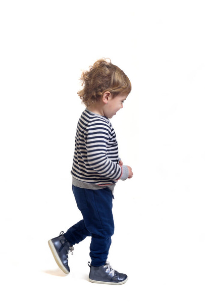 side view of a baby boy walking on white background - 写真・画像