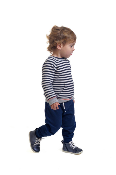 side view of a baby boy walking on white background - Фото, изображение