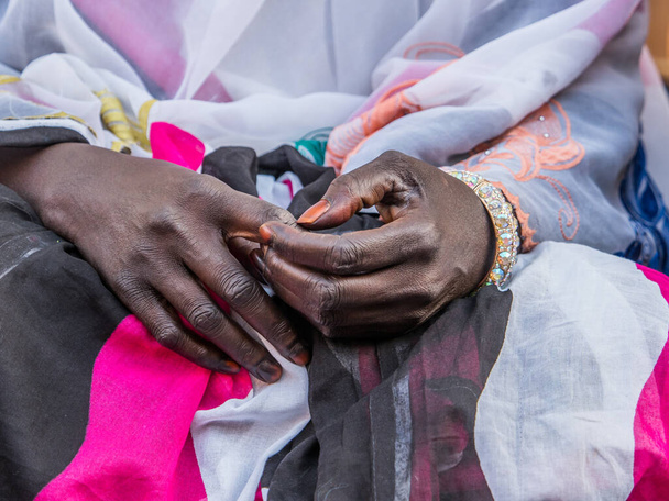 Negro manos bien arregladas de una mujer africana en el fondo de un vestido colorido - Foto, imagen