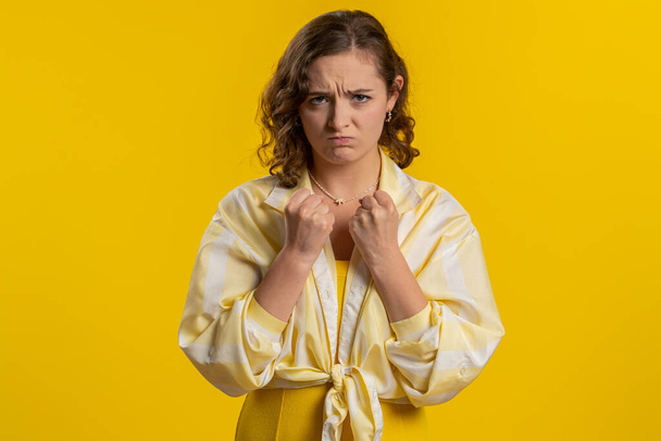 Offended sad nervous woman having misunderstanding, frustrated after quarrel, fail, lose, ignores and does not want to communicate, talk. Girl isolated on yellow studio background. People lifestyle - Φωτογραφία, εικόνα