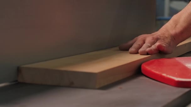 Close-up van de werknemer snijden van houten plaat met machine. Creatief. Zelfgemaakte machine voor het ontladen van houten platen in de werkplaats. Man snijdt houten plaat met gereedschapswerktuig in creatieve werkplaats.  - Video