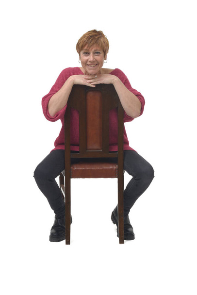Nainen istuu tuolilla kääntyi ja katselee kameraa - Valokuva, kuva
