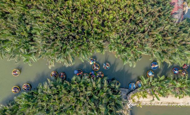 Luftaufnahme eines Kokosnussdorfes Korbschifffahrt. Palmenwald in Hoi An, Cam Thanh, Vietnam. Touristen bei einem Ausflug und Spaß in Thu Bon Fluss - Foto, Bild