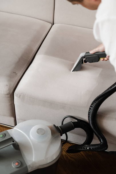 Line on couch after dry cleaning with washing vacuum cleaner extractor machine. Domestic cleaning service cleaner is removing dirt and dust from couch using dry cleaning extraction machine - Photo, Image