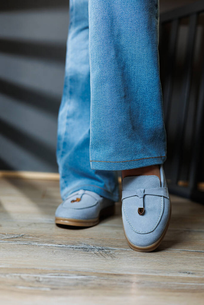 Schlanke Frauenbeine in Jeans und blauen Loafers. Kollektion von Sommerschuhen für Frauen. Stylische Damenschuhe für den Sommer - Foto, Bild