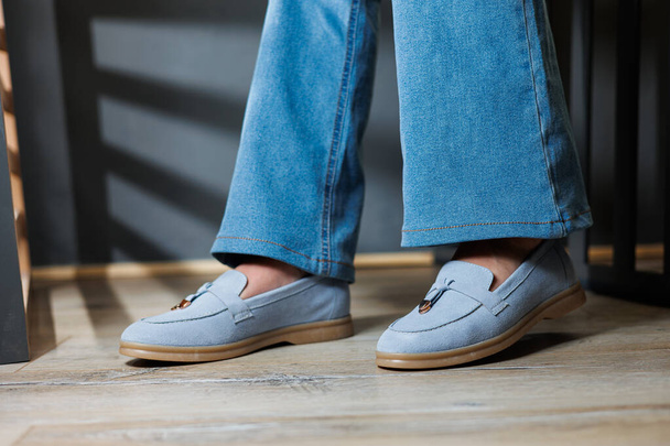Тонкие женские ноги в джинсах и синих мокасинах. Коллекция летней женской обуви. Стильная женская обувь на лето - Фото, изображение