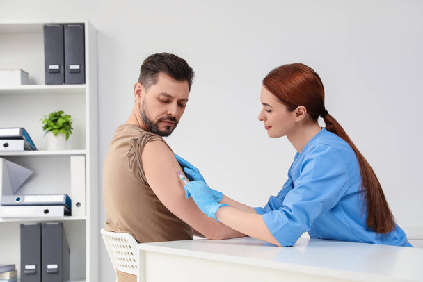 Doctor giving hepatitis vaccine to patient in clinic - Foto, Imagen